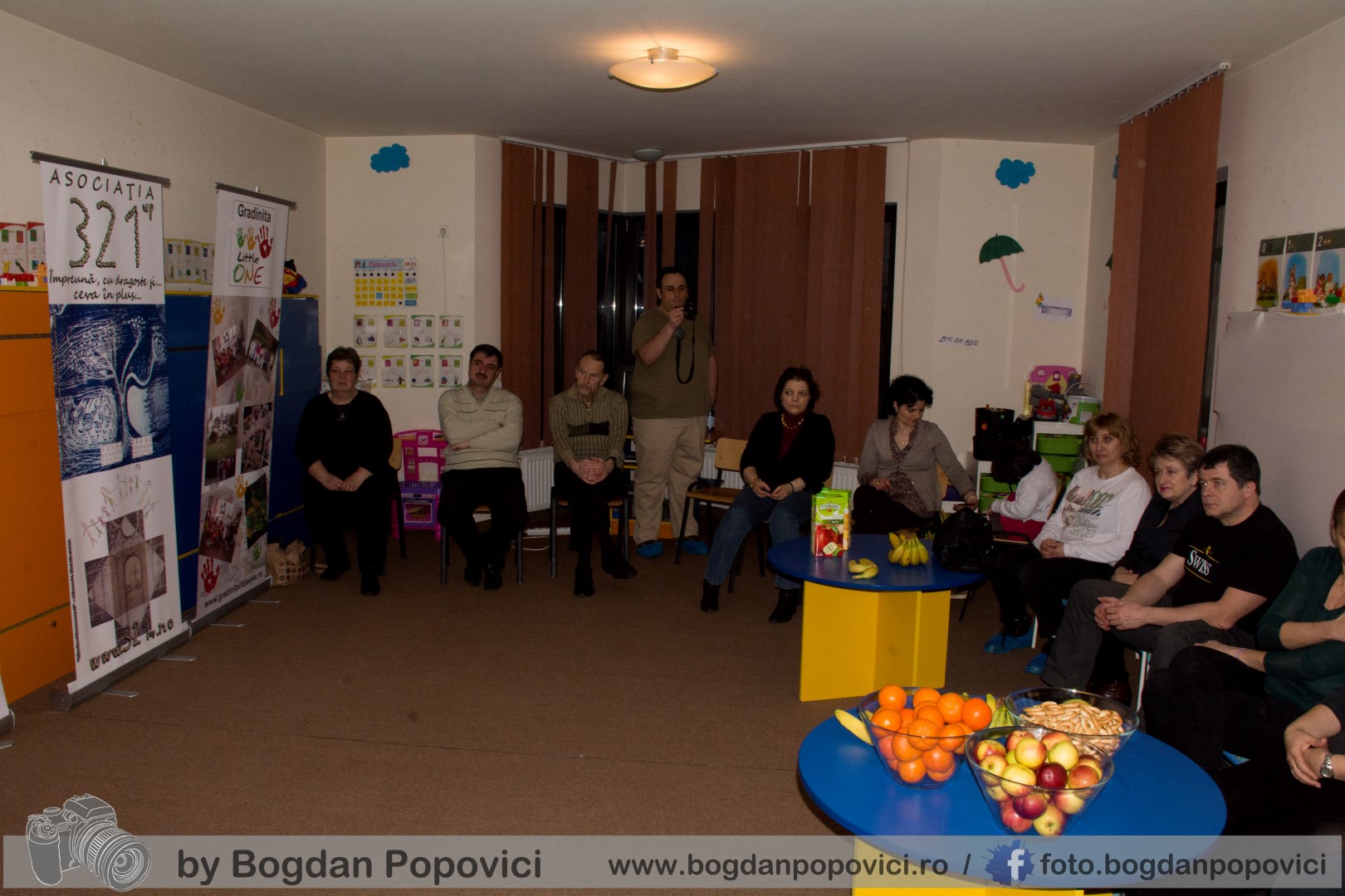 Copii și adulți adunați într-o sală la o întâlnire a asociației 321UP.